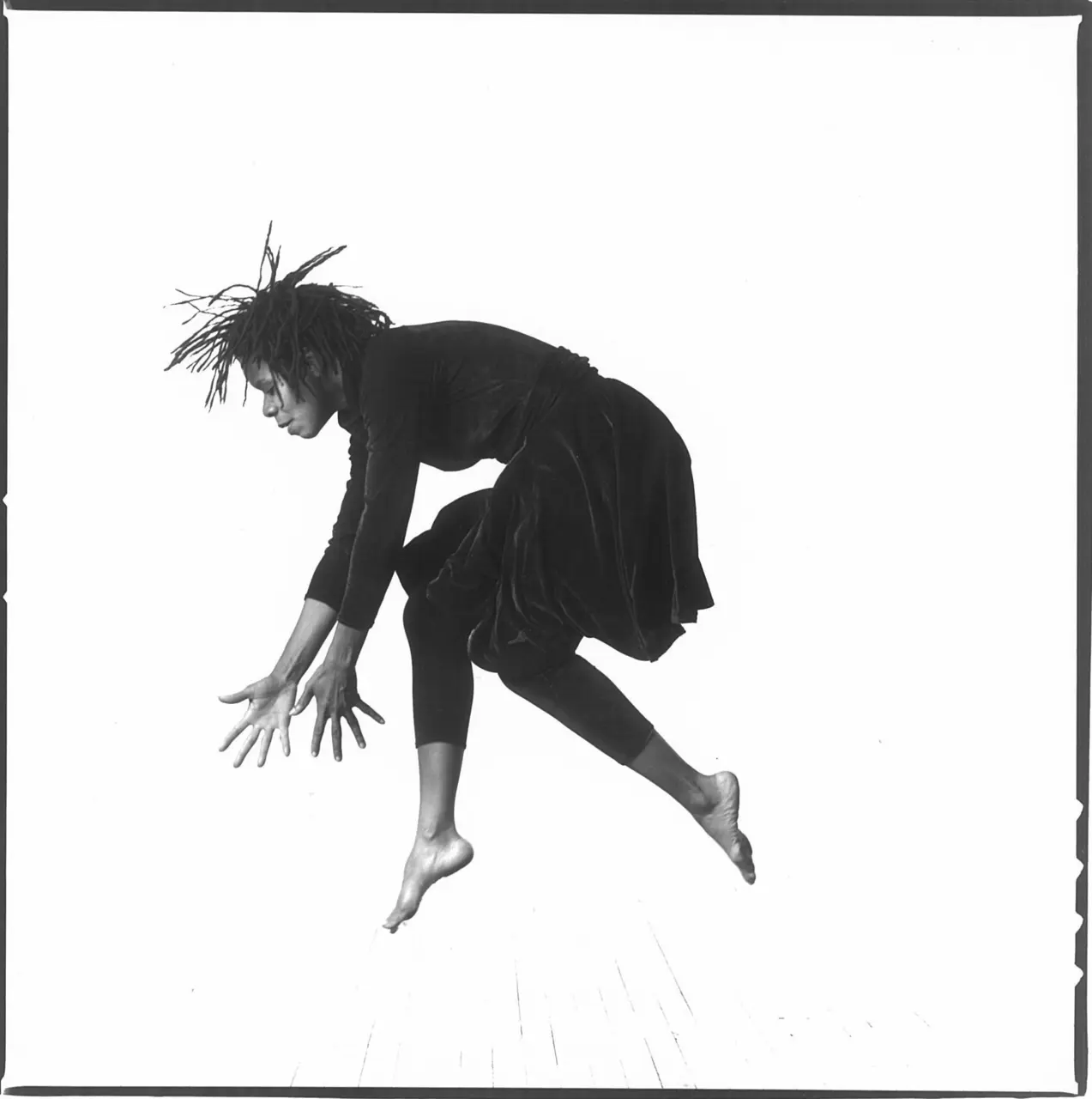 Bebe Miller Company dancer suspended in a forward-reaching movement
